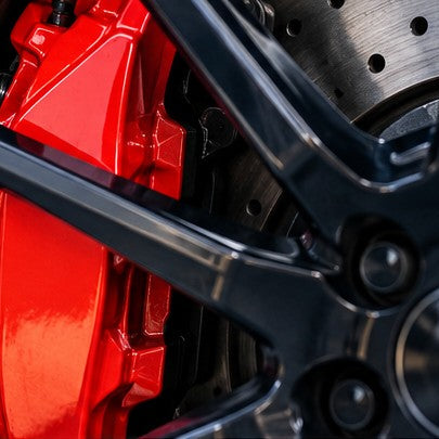 Illustrative glossy red painted brake caliper behind a black alloy wheel – best brake caliper paint UK guide